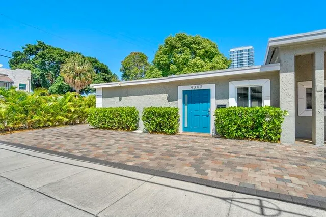 a front view of a house with a yard and potted plants