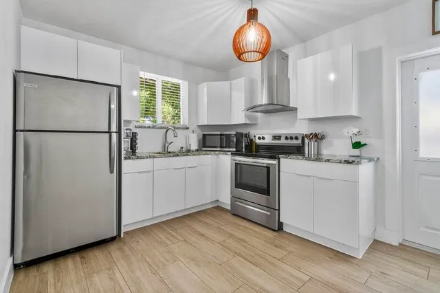 a kitchen with white cabinets and white appliances