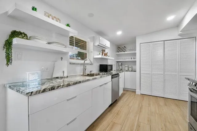 a kitchen with a sink cabinets stainless steel appliances and a window