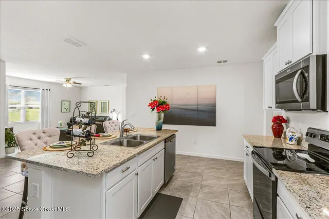 a kitchen with stainless steel appliances granite countertop a sink and a refrigerator