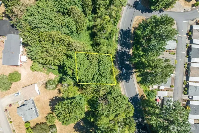 an aerial view of residential house with outdoor space and trees all around