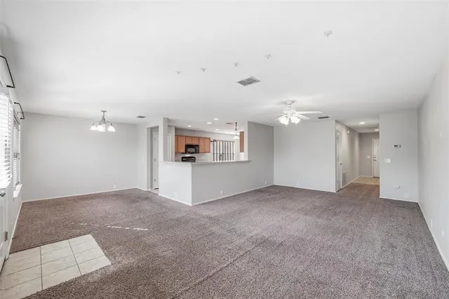 an empty room with kitchen and windows