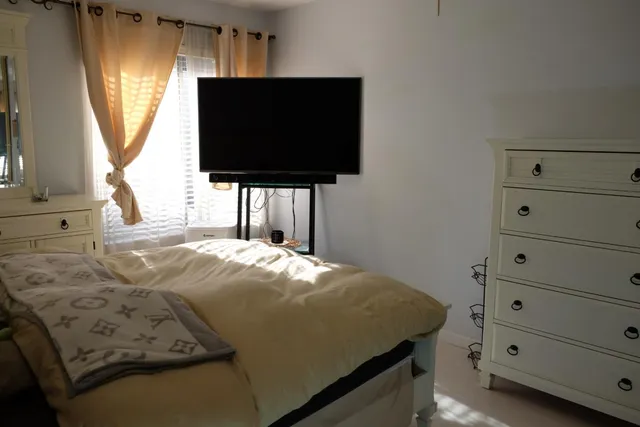 a bedroom with a bed and flat screen tv