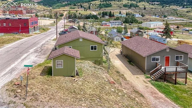 an aerial view of residential houses with outdoor space and street view