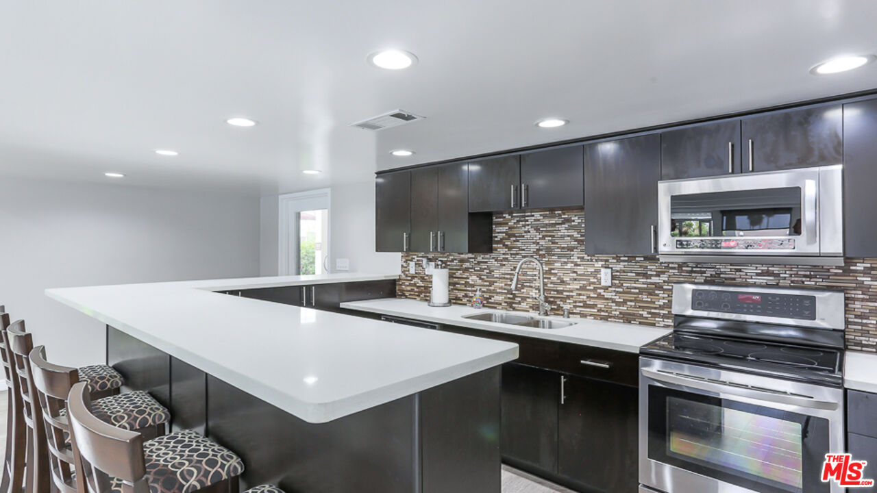 7250 Franklin Avenue, Unit 1112 Los Angeles, CA 90046 - Photo 21 of 29 a kitchen with stainless steel appliances granite countertop a kitchen island a stove and a sink