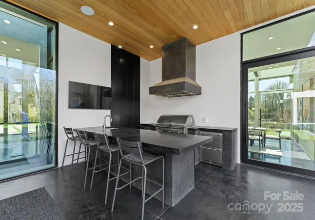 a kitchen with stainless steel appliances kitchen island granite countertop a table and chairs in it