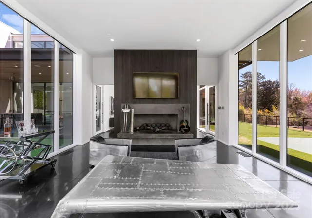 a living room with fireplace furniture and a large window
