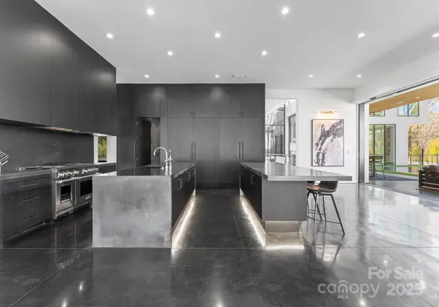 a view of a kitchen with kitchen island stainless steel appliances wooden floor dining table and chairs