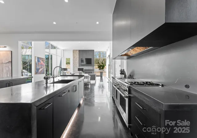 a kitchen with stainless steel appliances granite countertop a sink a stove and a refrigerator