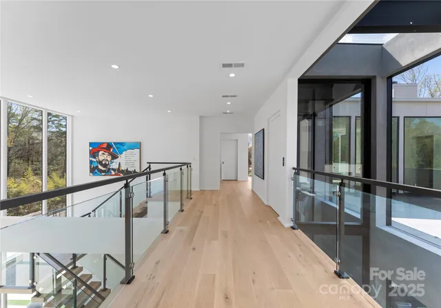 a view of a hallway with wooden floor and furniture