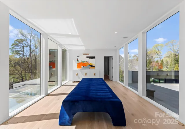 a hallway with wooden floor and large windows