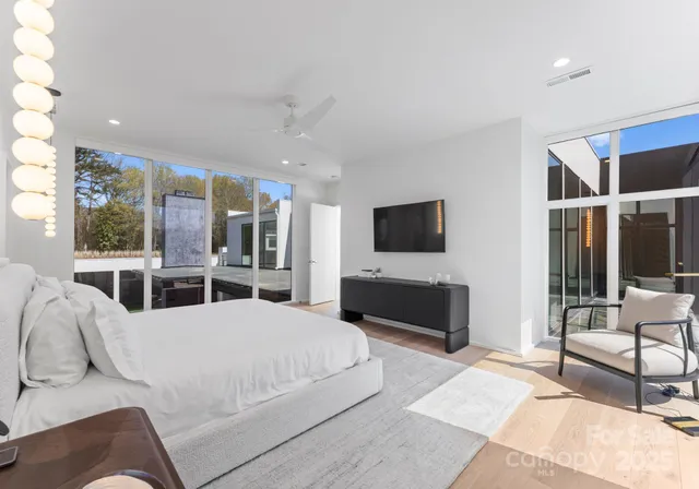 a living room with furniture a flat screen tv and a large window