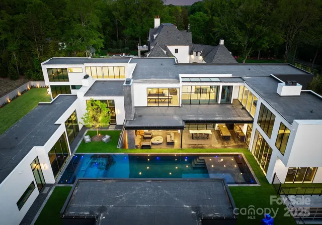 an aerial view of a house with swimming pool a yard and outdoor seating