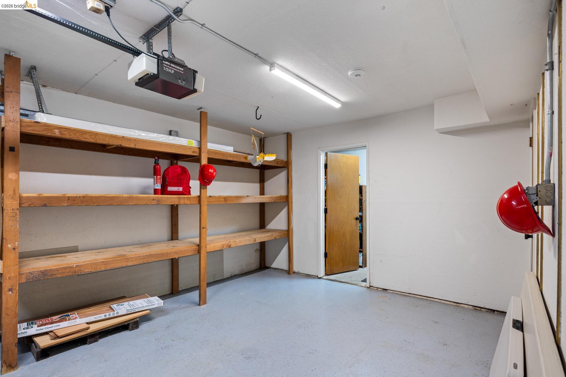 6660 Sobrante Road Oakland, CA 94611 - Photo 40 of 48 Garage with concrete flooring, fluorescent lighting, and built-in wood shelving