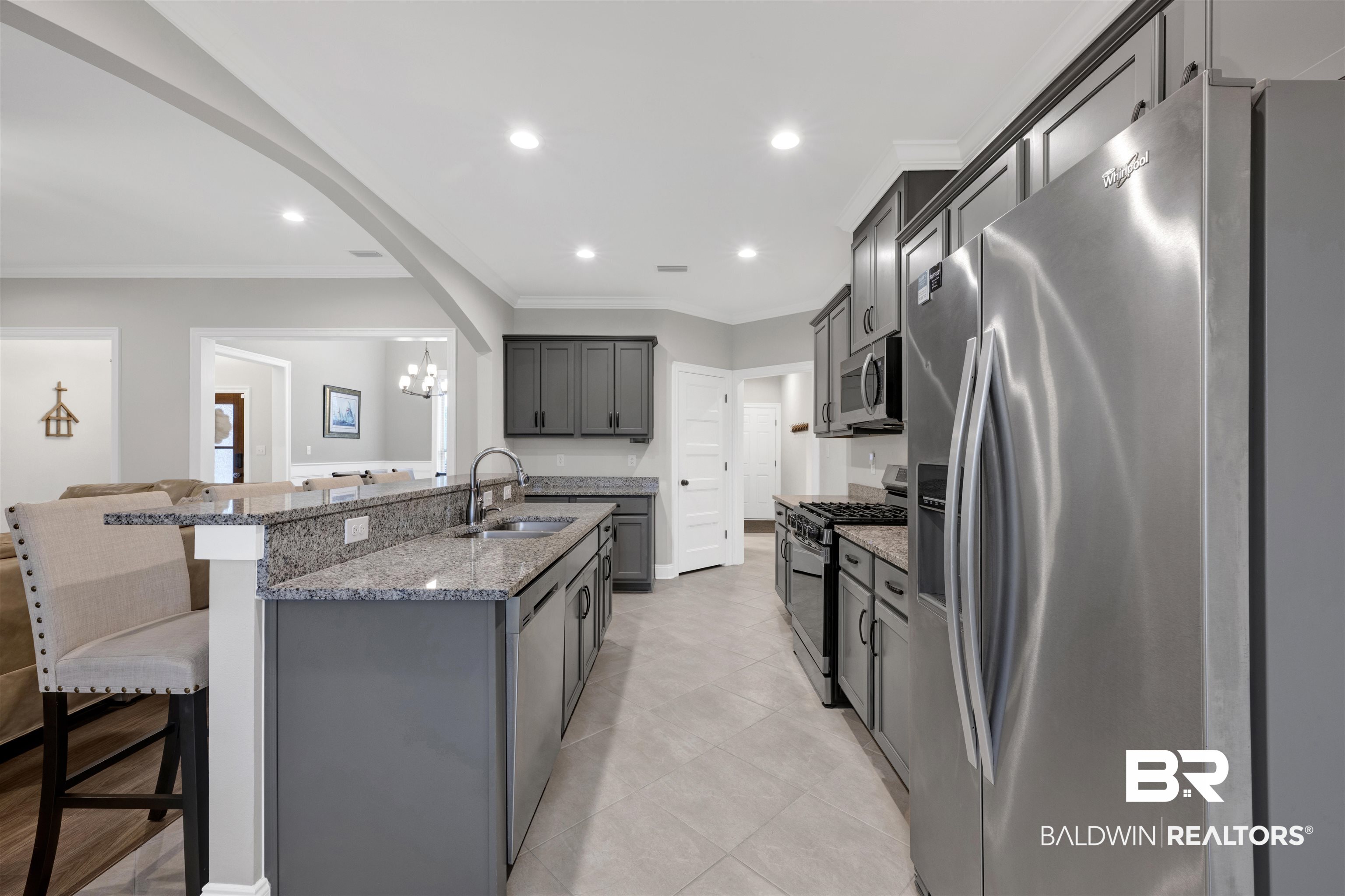 12672 Squirrel Drive Daphne, AL 36527 - Photo 17 of 49 Kitchen featuring an island with a double basin stainless steel sink, granite countertops, and gray cabinetry