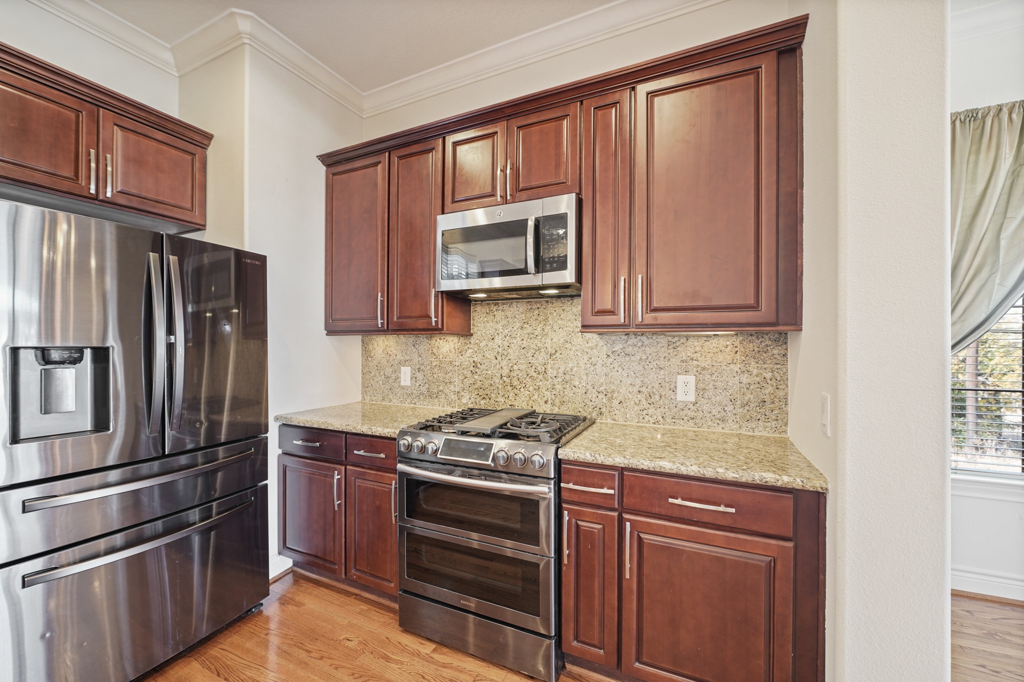 1402 Wheeler Avenue Houston, TX 77004 - Photo 15 of 40 a kitchen with granite countertop stainless steel appliances and wooden cabinets