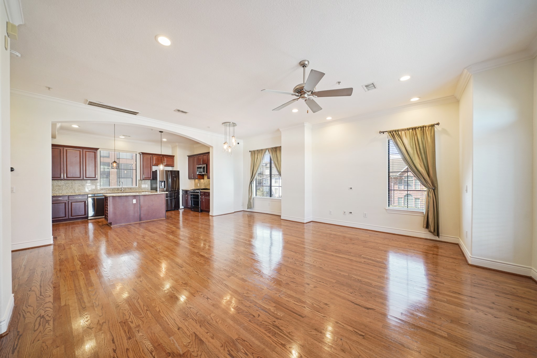 1402 Wheeler Avenue Houston, TX 77004 - Photo 9 of 40 a view of an empty room with wooden floor and a kitchen