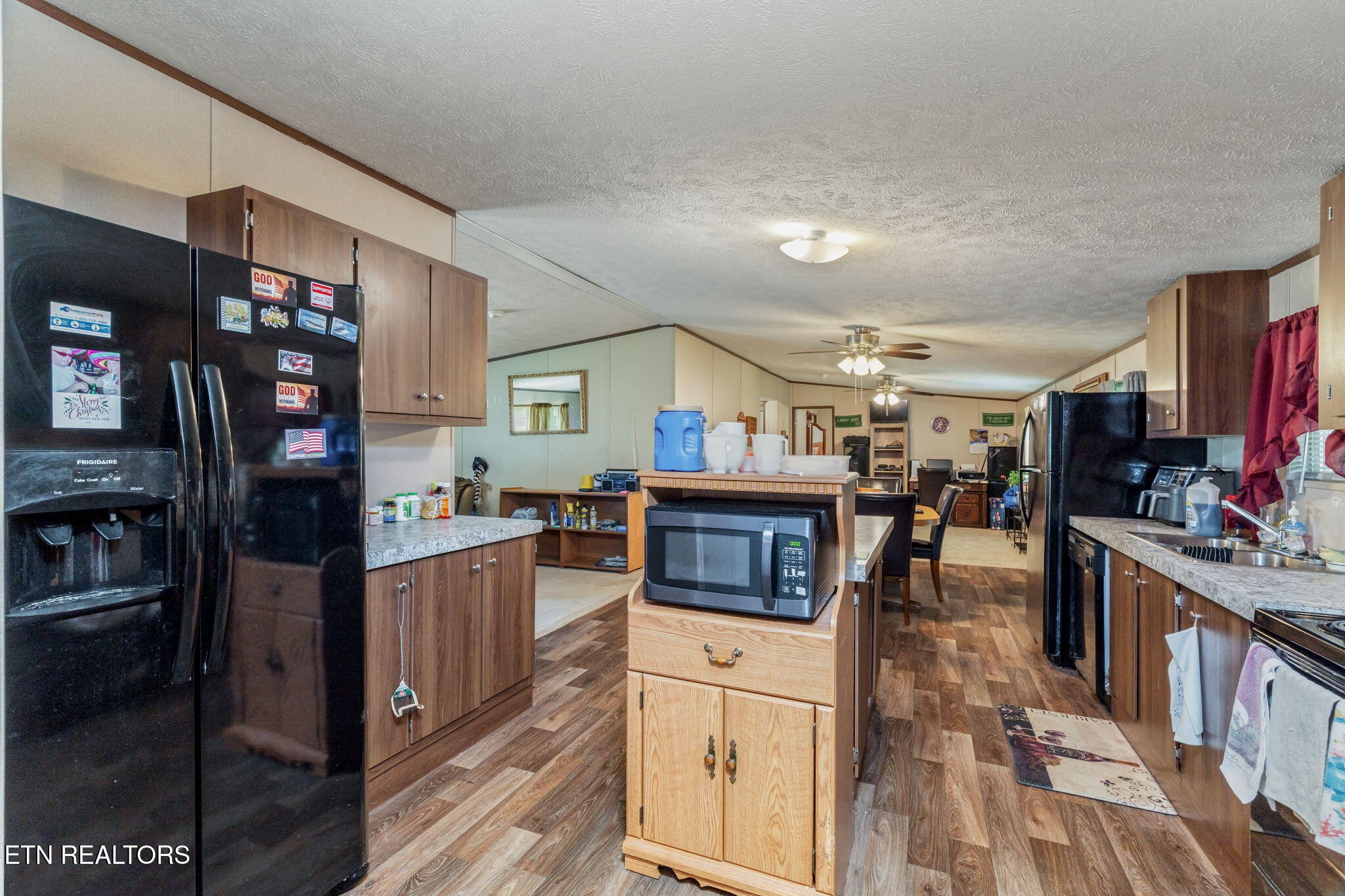 20156 Steekee Road Loudon, TN 37774 - Photo 16 of 46 a kitchen with stainless steel appliances kitchen island granite countertop a refrigerator oven stove a dining table and chairs with wooden floor