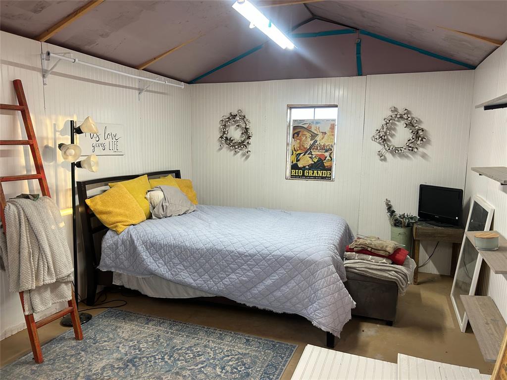 925 Clear Spring Road Stephenville, TX 76401 - Photo 17 of 26 a bedroom with a bed and wooden floor