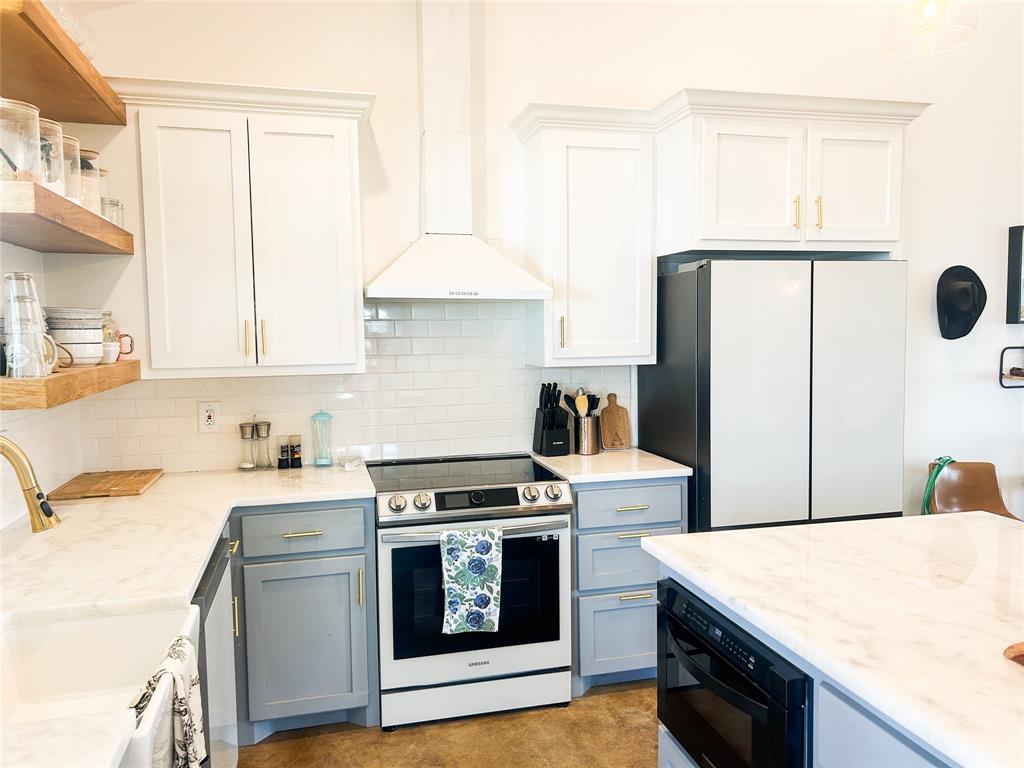 925 Clear Spring Road Stephenville, TX 76401 - Photo 6 of 26 a kitchen with a stove a sink and a refrigerator