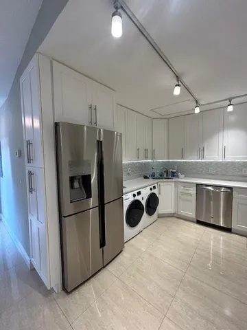 a kitchen with a refrigerator sink and stainless steel appliances