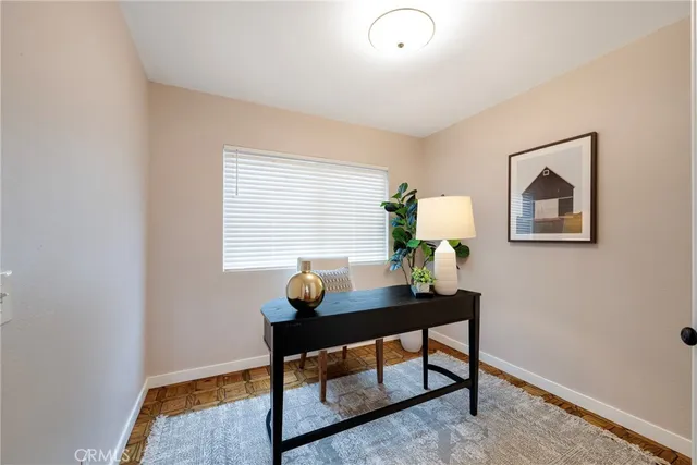an empty room with chandelier fan and windows