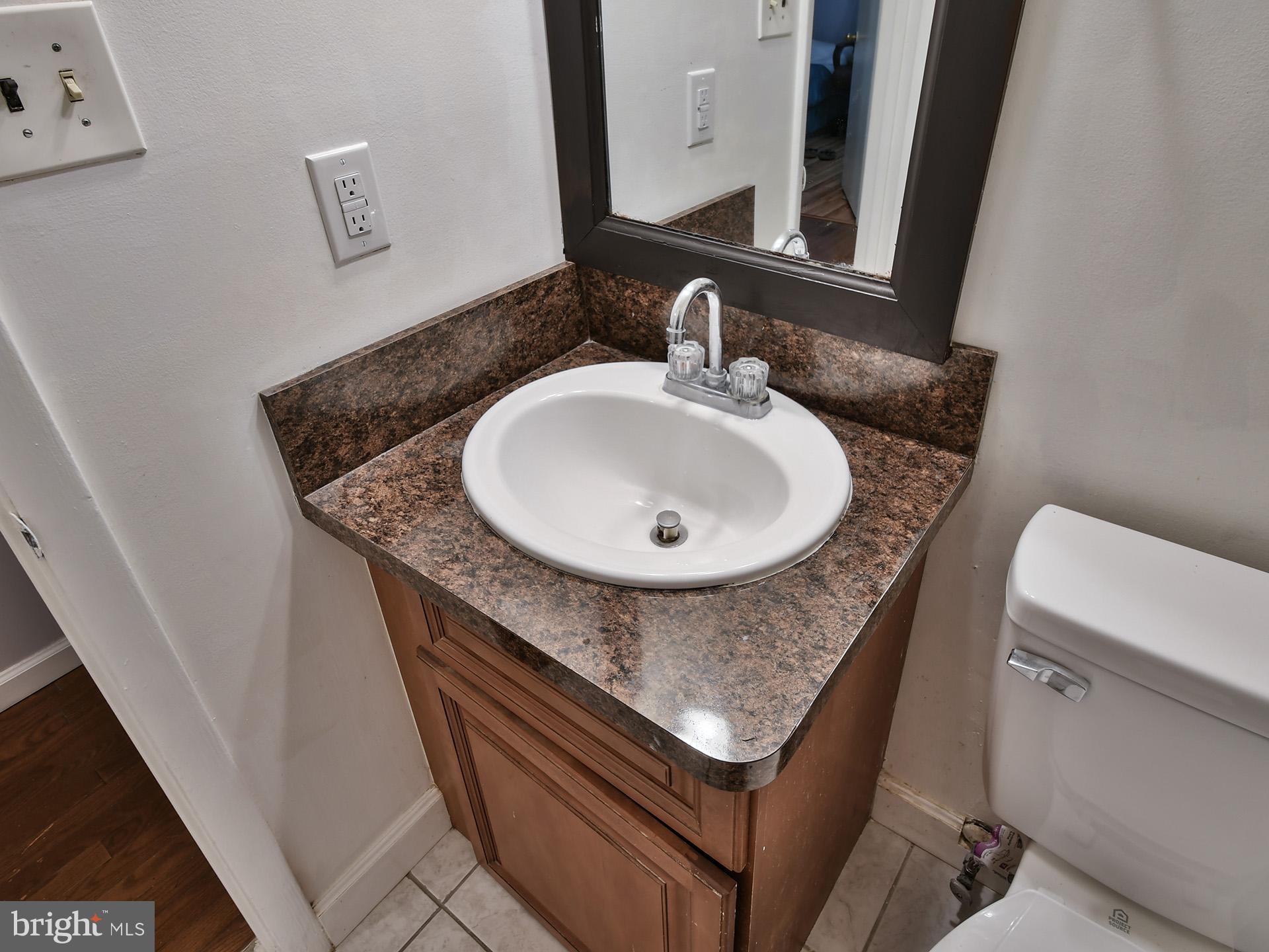 8600 Sumter Lane Clinton, MD 20735 - Photo 25 of 51 a bathroom with a granite countertop sink a mirror and a toilet