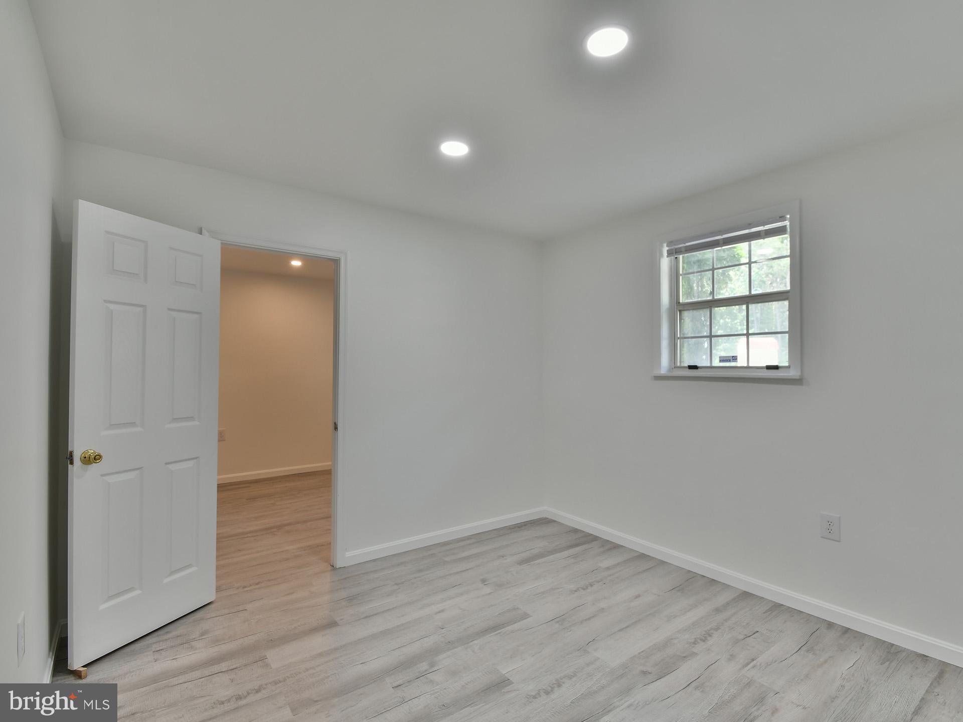 8600 Sumter Lane Clinton, MD 20735 - Photo 47 of 51 an empty room with wooden floor and windows