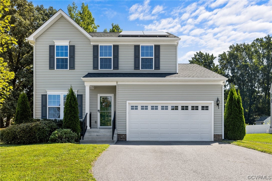 a front view of a house with a yard and garage