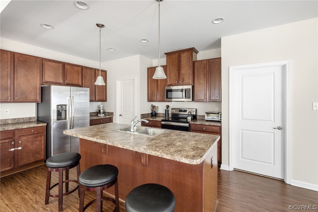 5419 Sandy Ridge Terrace Chesterfield, VA 23832 - Photo 10 of 27 a kitchen with stainless steel appliances granite countertop a sink a stove a refrigerator and island with wooden floor
