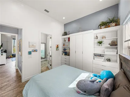 a bedroom with a bed wooden floor and furniture