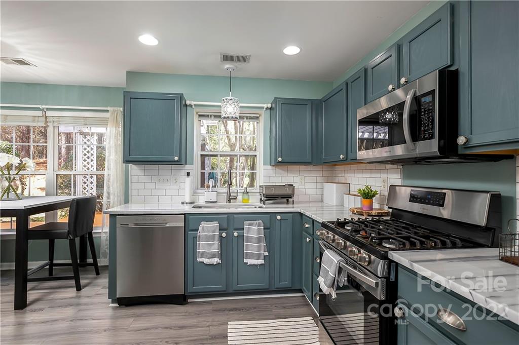 7601 Silverton Way Huntersville, NC 28078 - Photo 5 of 26 a kitchen with stainless steel appliances granite countertop a stove a sink and a microwave