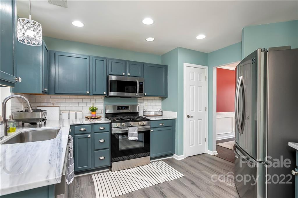 7601 Silverton Way Huntersville, NC 28078 - Photo 6 of 26 a kitchen with stainless steel appliances granite countertop a refrigerator a sink dishwasher a stove oven and a dining table with wooden floor