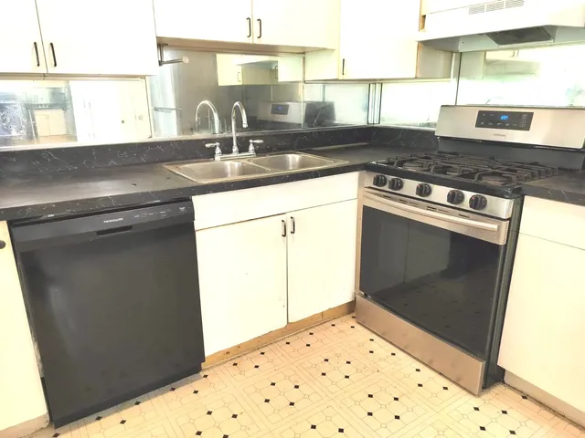 a kitchen with granite countertop white cabinets and black appliances
