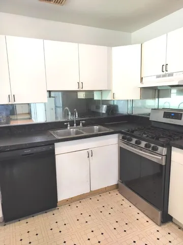 a kitchen with stainless steel appliances kitchen island granite countertop a sink a stove and a microwave