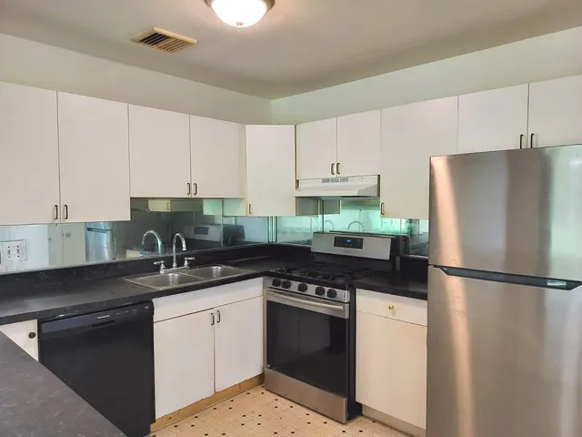 a kitchen with a refrigerator sink and cabinets