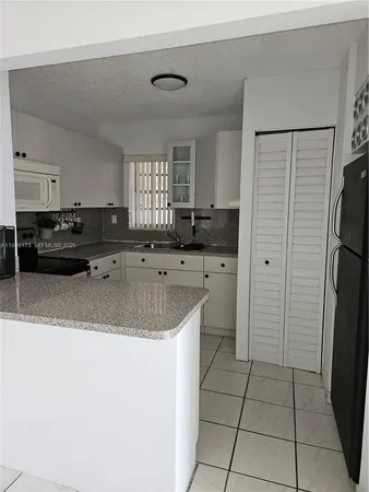 a large kitchen with a refrigerator a sink and dishwasher