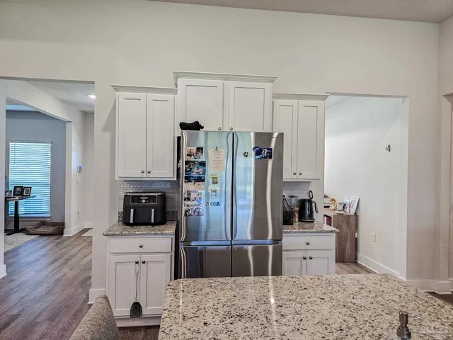 a kitchen with stainless steel appliances kitchen island granite countertop a refrigerator and a stove top oven