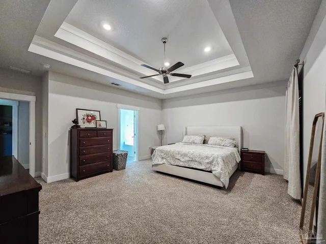 a spacious bedroom with a bed and a chandelier