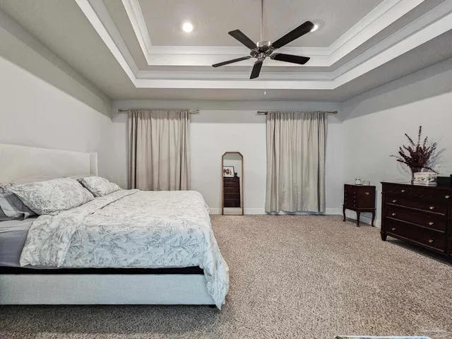 a bedroom with a large bed and a chandelier