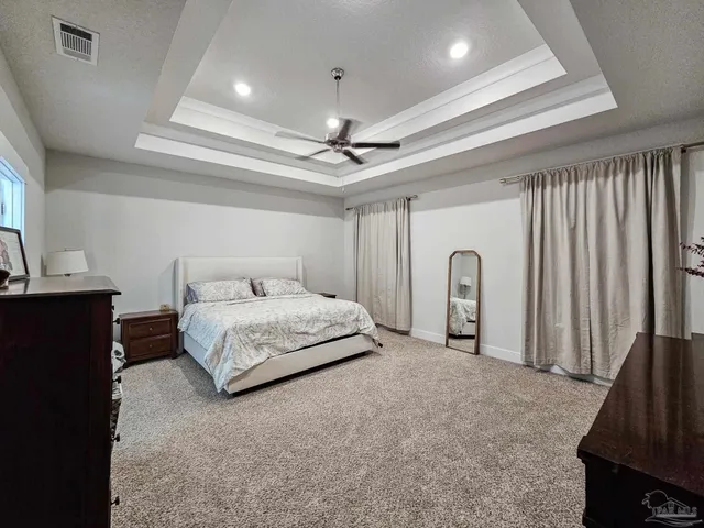 a spacious bedroom with a bed and a dresser