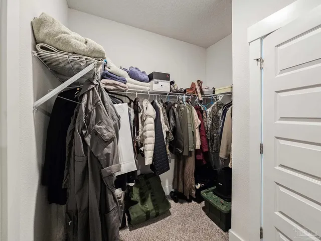 a view of walk in closet with clothes
