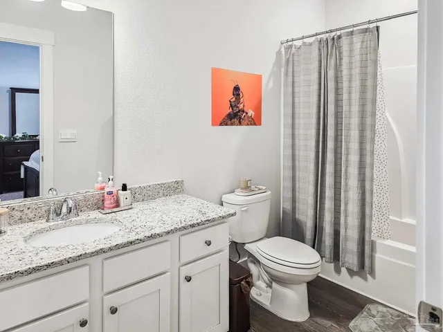 a bathroom with a granite countertop sink mirror vanity and toilet