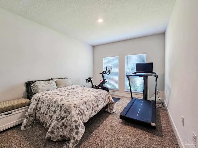 a bedroom with a bed a mirror and dresser