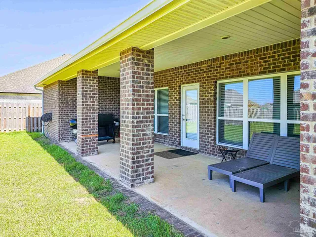 a patio area with table and chairs and potted plants