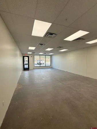 an empty room with windows and ceiling fan