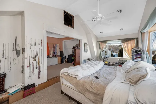 a bedroom with a large bed a flat screen tv and a large window