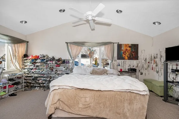 a bedroom with a bed and a flat tv screen on the dresser