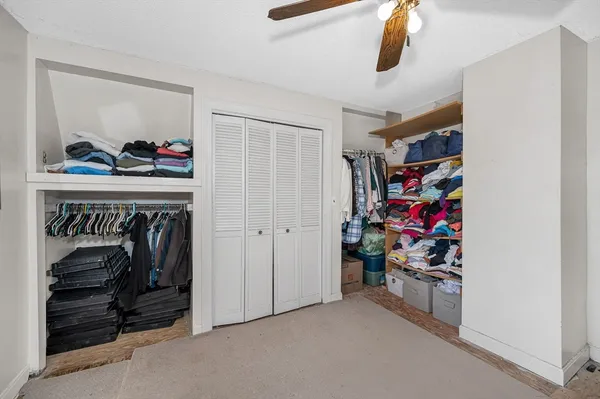 a view of walk in closet with clothes and shoes