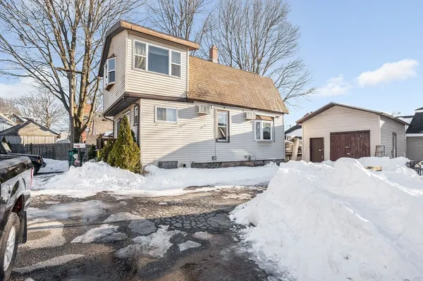a front view of a house with a yard covered in snow